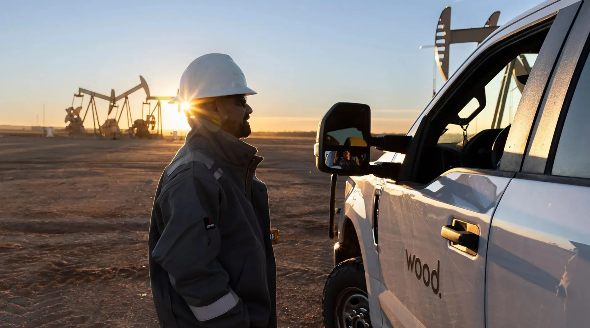 Man in a hard hat next to a car